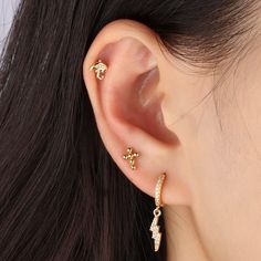 Designed with the shape of lightning, crafted in 14k gold with brass. The sparkling cz gems will definitely light up your whole piercing style and your outfit. Trendy Gold Piercings In Sterling Silver, Dainty Yellow Gold Piercings With Cubic Zirconia, Gold Piercings With Star Charm As Gift, Minimalist Gold Crystal Earrings For Pierced Ears, Gold Minimalist Cartilage Earrings With Moon Charm, Ear Style, Helix Earrings, Cartilage Piercing, Single Earring