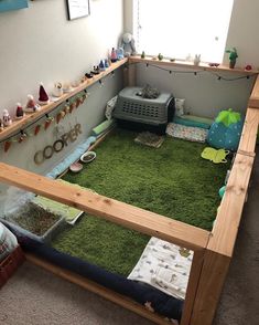 a room that has a bed with green carpet on the floor and toys in it