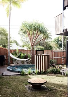 a backyard with a pool and hammock in the back yard, surrounded by palm trees