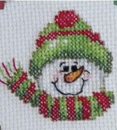 a snowman with a green hat and scarf