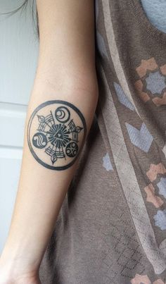 a woman's arm with a tattoo on it and a flower in the center