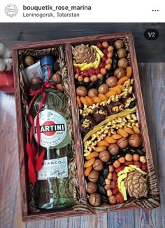 an open wooden box filled with different types of food and liquor bottles on top of a table