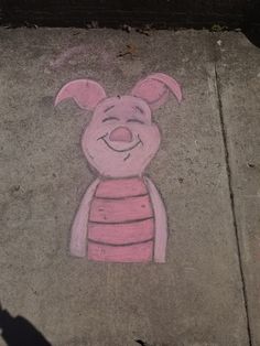 a drawing of a pig is on the sidewalk next to a person's shadow