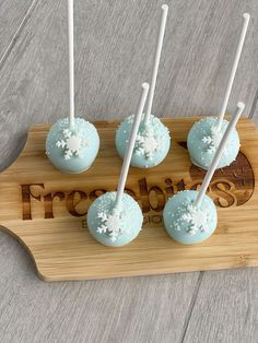 four blue cake pops with white frosting on them