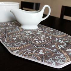 a place mat with a bowl on top of it next to a cup and saucer