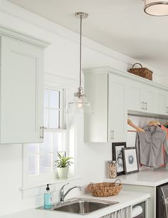 a kitchen with white cabinets and stainless steel dishwasher next to a washer and dryer