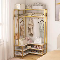 a gold shelf with clothes and bags on it next to a bed in a room