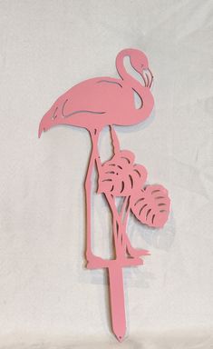 a pink flamingo standing on top of a tree branch with its head in the air