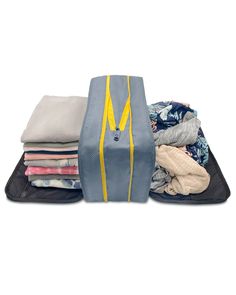 an open suitcase filled with clothes on top of a white surface