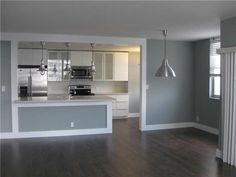 an empty kitchen and living room with hard wood floors