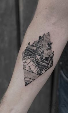 a man's arm with a castle tattoo on the left side of his arm