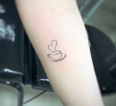 a small coffee cup tattoo on the arm