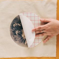 a person is making a photo on a piece of paper with their hands and fingers