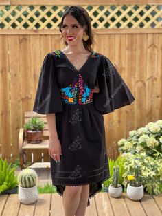 This Beautiful Dress boasts a Traditional Mexican floral design combined with a modern style dress. The embroidered bodice combined with the bell sleeves makes it fun and flirty. It's made out of fine Mexican cotton and has elastic on the back for an adjustable fit. This dress is handmade and hand embroidered by Mexican Artisans in Oaxaca, Mexico. This dress comes in one size: Medium/Large Purchase the shoes modeled here: https://www.etsy.com/es/listing/1001211818/tacones-mexicanos-pintados-a-ma Bohemian Fitted Dresses With Yoke Detail, Black Folk Dress With Embroidered Hem, Black Bohemian Dress With Embroidered Sleeves, Fitted V-neck Embroidered Dress For Festival, Fitted V-neck Embroidered Festival Dress, Festival Fitted V-neck Embroidered Dress, Black Bohemian Dress With Embroidered Neckline, Folk Style Fitted Dress With Embroidered Neckline, Black Bohemian Embroidered Dress With Geometric Pattern