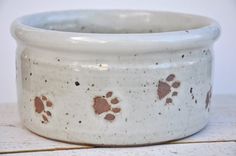 a white bowl with brown paw prints on it