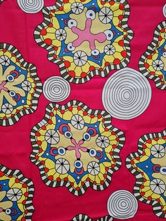 a red and yellow fabric with circular designs on it