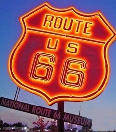 the route 66 sign is lit up in red and yellow for people to see it