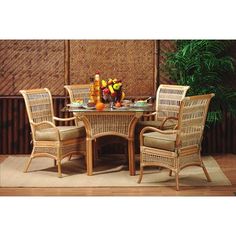 an outdoor dining table with four chairs and fruit on the plate in front of it