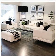 a living room with white furniture and black accents