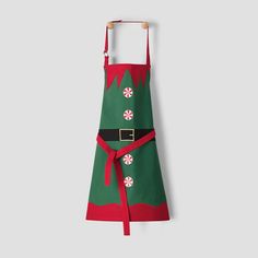 a green and red christmas apron hanging on a wall