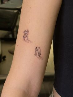 two small tattoos on the arm of a woman