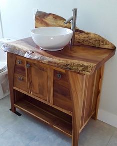 a bathroom sink with a bowl on top of it and a toilet in the background