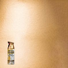 a can of spray paint sitting on top of a wooden table next to a wall