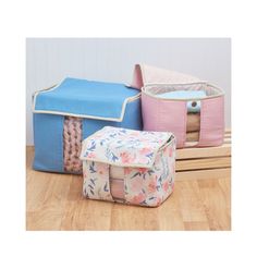 three storage bags sitting on top of a wooden floor