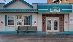 an empty bench sits in front of the missy's pizza place, which is closed for business