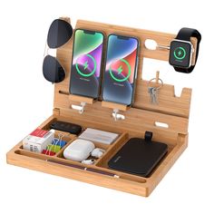 an open wooden box with two iphones and other electronics in it's compartments