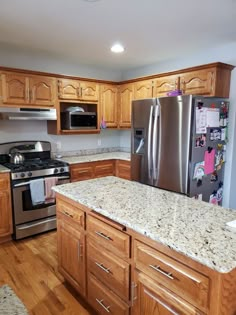 a kitchen with granite counter tops and stainless steel appliances in the center, along with wooden cabinets