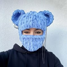 a woman wearing a blue knitted bear mask