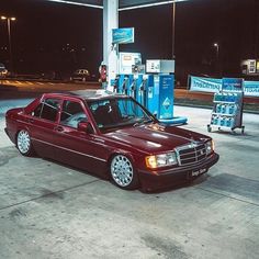 a red car parked in front of a gas station