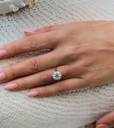 a woman's hand with a diamond ring on it