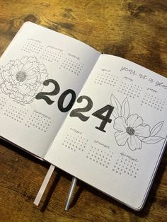 an open planner with flowers on it and the numbers twenty - four in black ink