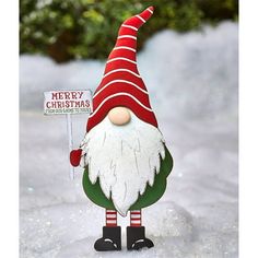 a christmas gnome holding a merry sign in the snow