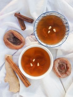 a cup of tea next to some cinnamon sticks