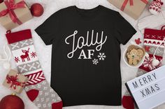 Jolly AF T-shirt. This listing is for 1 Adult Unisex crewneck t-shirt in colors- in Black, Red, or Kelly Green shirts (Colors are shown in listing photos). Lettering Vinyl is in white. If you would like a different shirt color, child sizes, or vinyl color, please message me for more options To Order: 1. Choose size  2. Choose your shirt color. 3. Add to cart **For multiple shirts-repeat this process if different sizes or colors** Shirt Colors may vary slightly - depending on your screen. 100% Cotton, Gildan brand Saying is on front of shirt only. Back of shirt is blank. Please let me know if you need an item by a certain date as this does not include shipping time. Each item is shipped with tracking number. There are no returns on items but I will do everything I can to make sure the custo Jolly Af, Green Shirts, Christmas Shirt Funny, Holiday Clothes, Funny Xmas, Funny Christmas Shirts, Merry Xmas, Vinyl Colors, Kelly Green