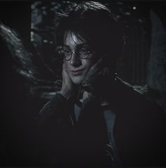 harry potter in the dark holding his hand to his face and looking at the camera