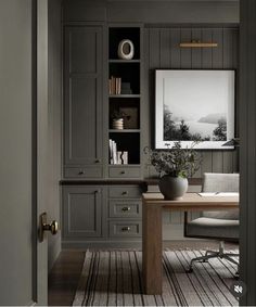 an office with gray walls and wooden floors is pictured in this image, there are bookshelves on either side of the desk