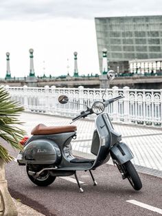 a motor scooter parked on the side of a road next to a fence