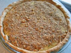 a pie sitting on top of a metal pan covered in toppings and crumbs