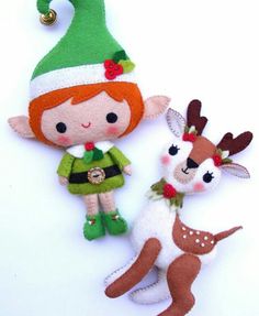 two stuffed animals are sitting next to each other on a white background with an elf's hat