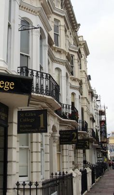 a row of white buildings with black balconies