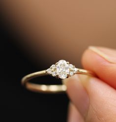 a close up of a person holding a ring with two diamonds on it's side