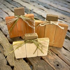 three wooden blocks with twine tied around them sitting on top of a wooden table