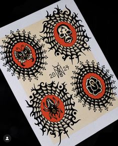 three spider web stickers on top of a white paper with black and orange designs