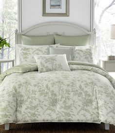 a bed with green and white comforters in a bedroom