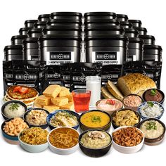 a large assortment of food is displayed in front of many black containers and one white cup