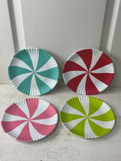 three paper plates with candy canes on them sitting in front of a white door